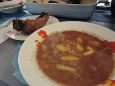 a bowl of soup on a table with other dishes in the background