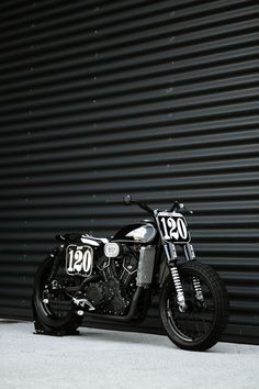 a motorcycle parked in front of a garage door with the number 001 on it