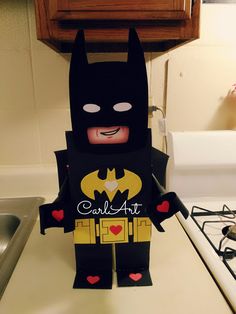 a paper cut out of batman standing on top of a kitchen counter next to a stove