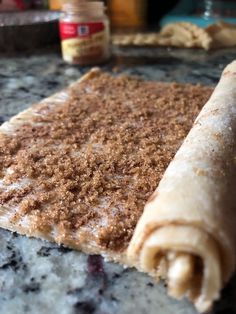 a crumb covered pastry sitting on top of a counter next to a jar of peanut butter