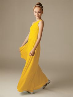 a young woman in a yellow dress poses for the camera with her hand on her hip