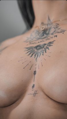 a woman with tattoos on her chest is looking at the camera