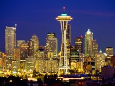 the seattle skyline is lit up at night