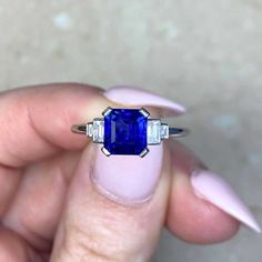 A geometric engagement ring featuring a 1.68 carat emerald-cut natural sapphire, set in prongs and displaying a deep blue color. A graduating design of baguette cut diamonds sits on either side of the center stone. The total diamond weight is 0.24 carats, H color and VS2 clarity overall. This ring is handcrafted in platinum.
The dimensions of the center stone are approximately 6.63mm x 6.08mm x 3.80mm.
This ring can be resized to any finger size at no extra cost.
Ready to Make It Yours? Contact Luxury Platinum Sapphire Ring With Prong Setting, Luxury Classic Sapphire Ring With Prong Setting, Geometric Engagement Ring, Estate Diamond Jewelry, Baguette Cut Diamond, Platinum Ring, Sapphire Stone, Perfect Engagement Ring, Natural Sapphire