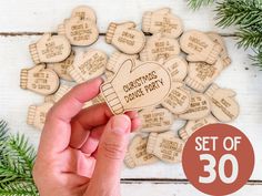 a hand holding up a wooden christmas ornament with the words, set of 30