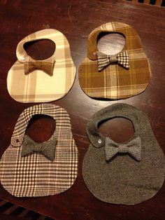 four bibs with bow ties on them sitting on a table