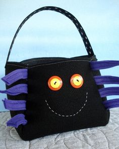 a black bag with orange eyes and purple hair on the inside is sitting on a bed