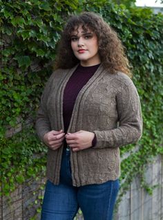 a woman standing in front of a fence with her hands on her hips and looking at the camera