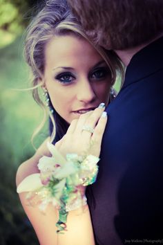 a woman is posing with her hands on her face and holding flowers in front of her face