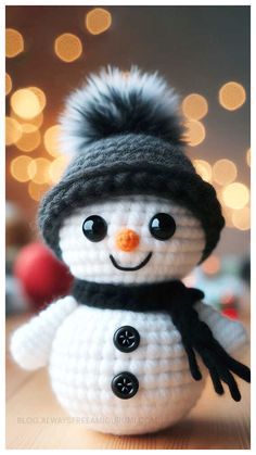 a crocheted snowman with a black hat and scarf