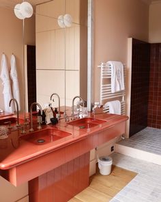 a bathroom with two sinks and towels hanging on the rack in front of the mirror