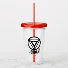 a glass with a red lid and a straw in front of a marble counter top