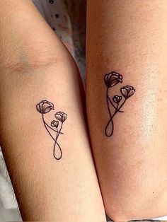 two women with tattoos on their legs are holding each other's hands and one has a flower tattoo on her arm