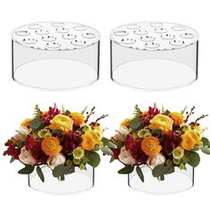 two clear vases with flowers and greenery in them on a white background, one is empty