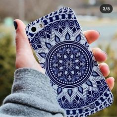 a person holding up a cell phone case with an intricate design on the front and back