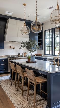 a large kitchen with blue cabinets and an island in the middle is surrounded by chairs