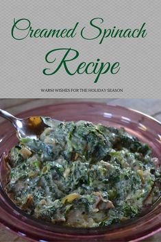 a bowl filled with spinach and cheese on top of a table next to a spoon