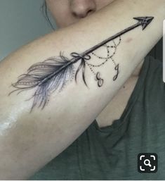 a woman with a tattoo on her arm and an arrow in the middle of her arm