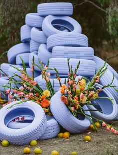 a bunch of tires stacked on top of each other in front of flowers and lemons