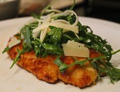 a white plate topped with meat and greens on top of it's side dish