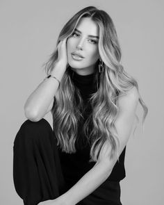 a woman with long hair sitting on the ground