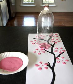 the process is being made with pink and black paint on white paper, then using cherry blossom stencils