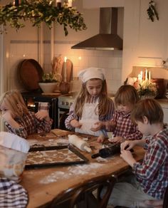 four children are making cookies in the kitchen