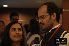 a man and woman standing next to each other with microphones in front of them