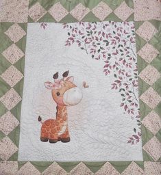 a baby giraffe quilted on top of a bed