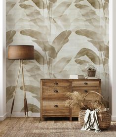 a room with a dresser, lamp and wallpaper in shades of brown on the walls