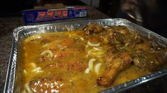 a pan filled with meat and noodles on top of a counter