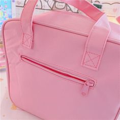 a pink handbag sitting on top of a table next to a wall with graffiti