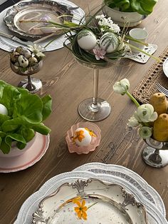 the table is set with plates, silverware and flowers