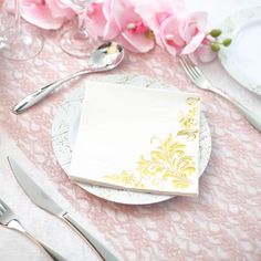 the table is set with pink flowers and silverware