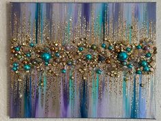 an abstract painting with blue and gold colors on it's side, hanging on a wall