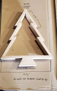 a cardboard box with a cutout of a christmas tree on the bottom and measurements below it