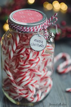 a jar filled with candy canes on top of a table