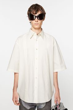 Short sleeve button-up shirt is cut to a relaxed fit and below hip length. Crafted from cotton and detailed with front patch tapes. FN-MN-SHIR000742 White Shirt With Concealed Placket For Summer, Oversized Cotton Shirt With Concealed Placket, Modern White Short Sleeve Cotton Shirt, Modern White Cotton Short Sleeve Shirt, White Cotton Shirt With Concealed Placket, Summer Cotton Shirt With Straight Hem, Cotton Tops With Concealed Placket For Daywear, Cotton Shirt With Button Closure And Straight Hem, Relaxed Fit Cotton Shirt With Concealed Placket