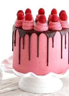 a cake with raspberries and chocolate drizzled on top