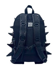 Black Out black backpack is your ticket to making an unforgettable statement. This black backpack's bold spike design and faux reptile texture commands attention and exudes confidence that sets you apart from the crowd. EXTERIOR Dimensions: 18" x 14" x 8" • Two zipper side pockets • Ergonomic mesh extra back padding • Adjustable Straps with chest strap for custom sizing • Heavy duty zippers with metal hardware • Top loop for hanging INTERIOR Padded laptop compartment protects electronics • Fits