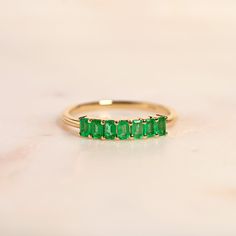 Featuring a row of rich emeralds, this ring is a wearable piece of art. Exquisite as a pop of color on it's own, or as a complimentary piece to your ring stack, our emerald demi band makes the perfect addition to your jewelry collection. Shop our full Demi Band Collection and discover all the color options on this exquisite design. Ring Stack, Pop Of Color, Stacking Rings, Exquisite Design, Emerald Cut, Birthstone, Color Options, Jewelry Collection, Color Pop