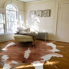 a living room with a large rug on the floor next to a couch and window