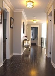 an empty hallway with hard wood floors and white trim on the walls is pictured in this image