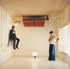 two people sitting on chairs in an empty room