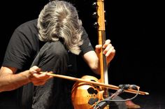 a man with long gray hair playing an instrument