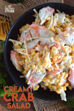 a black plate topped with pasta and meat covered in cream sauce on top of a table