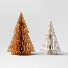 two white and brown paper christmas trees sitting next to each other