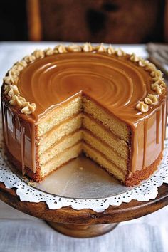 a cake that has been cut in half on a wooden platter with a white doily