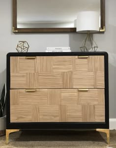 a black and brown dresser sitting next to a mirror