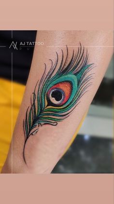 a colorful peacock feather tattoo on the leg